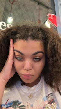 a woman with curly hair in front of a store